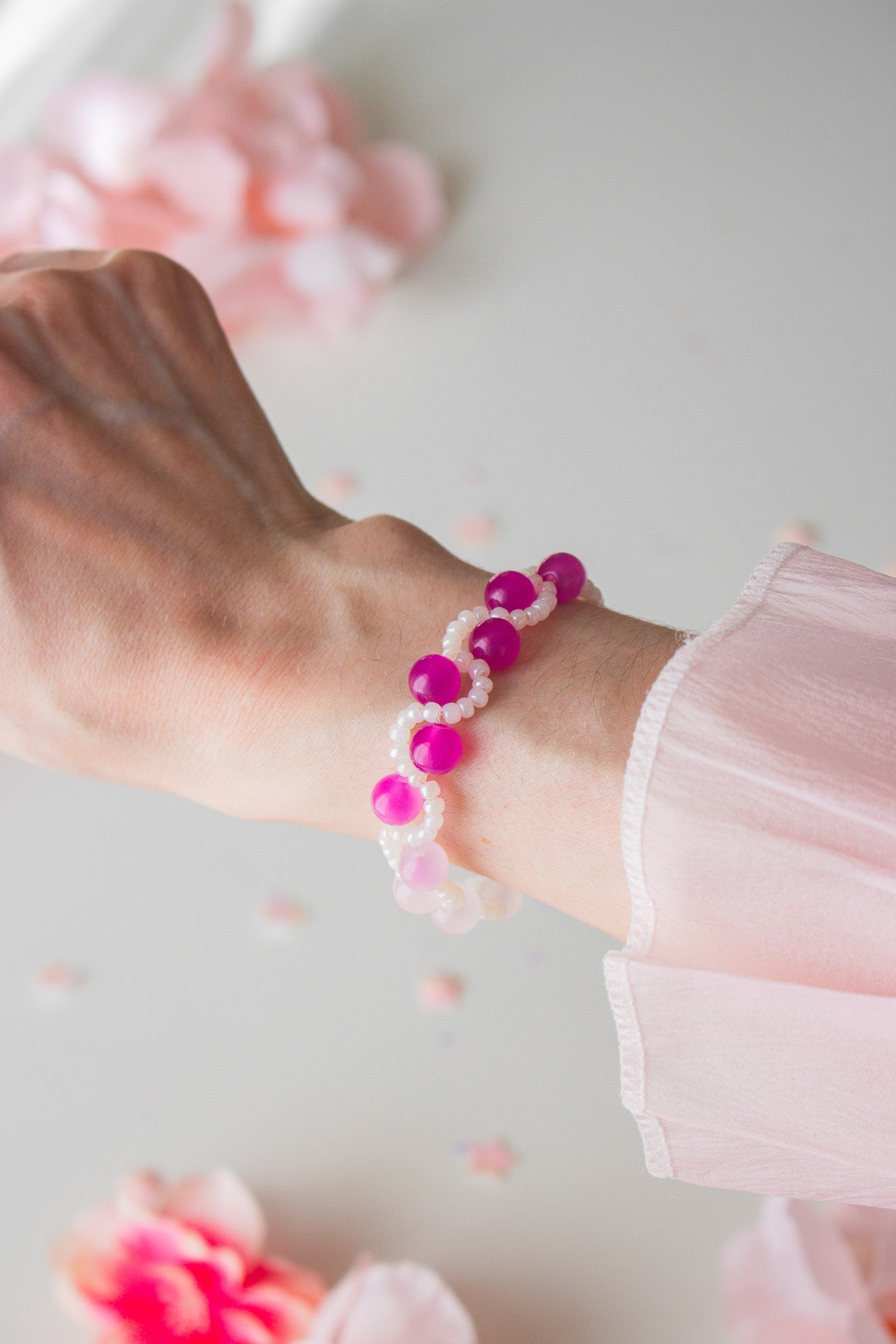 Handgefertigtes UV-Armband mit leuchtend pinken Magenta-Perlen und weißen Miniperlen – Detailansicht