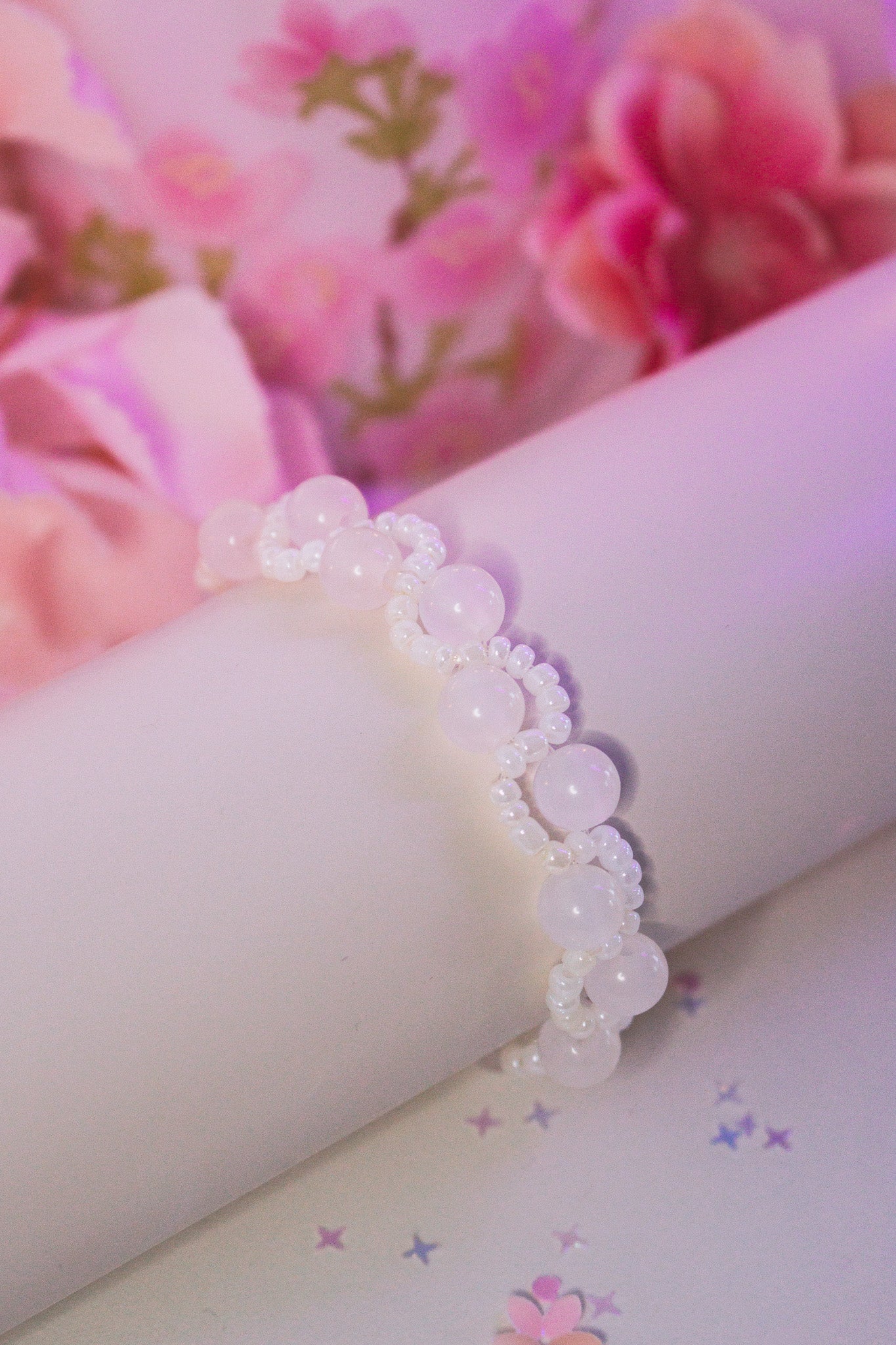 Handgefertigtes UV-Farbwechsel Armband mit großen rosa-roten Acrylperlen und kleinen weißen Perlen auf elastischem Nylonband