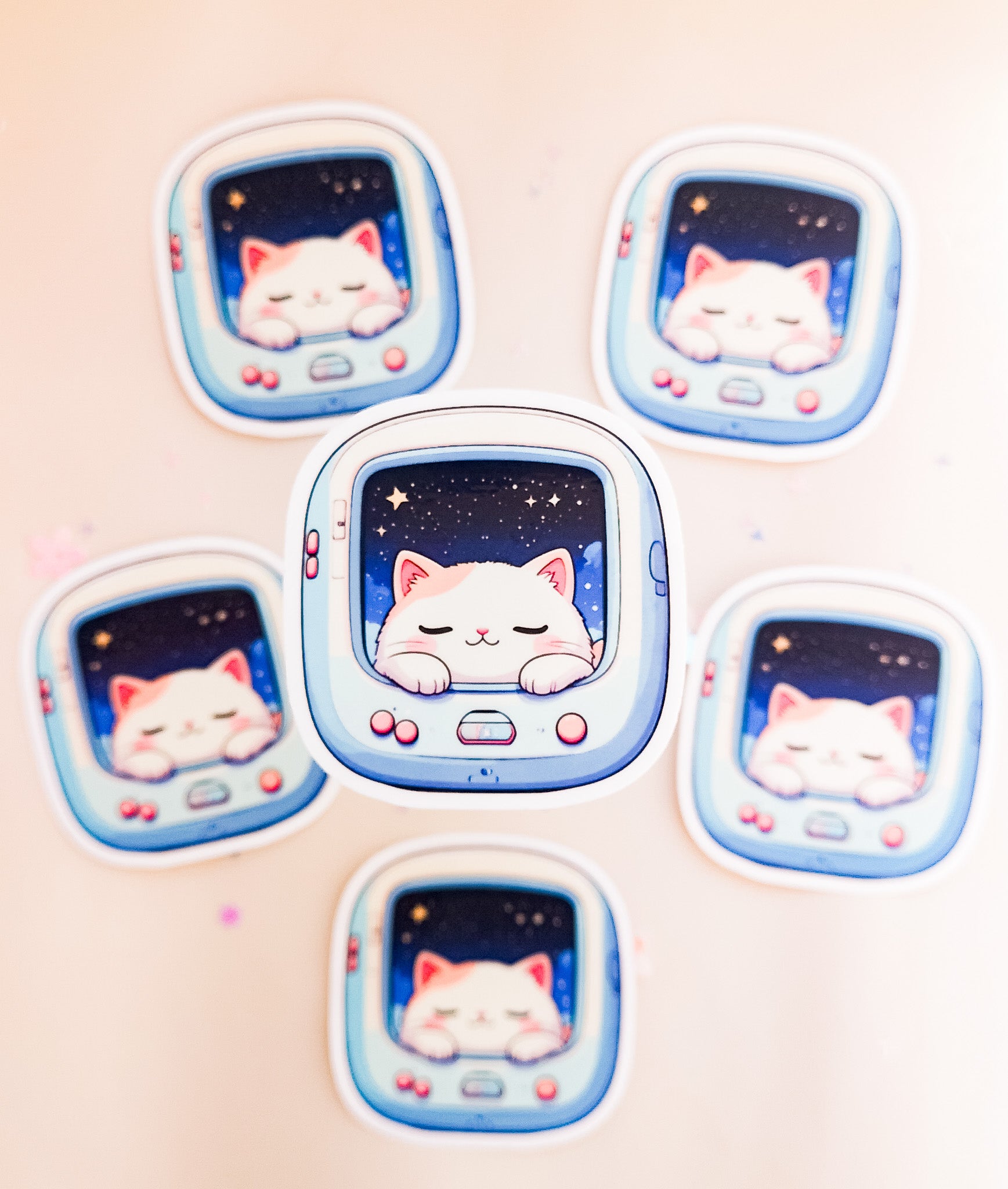 Sechs kawaii Space Cat Vinyl Sticker, schlafendes weißes Kätzchen im hellblauen Retro-Pet-Gerät mit Sternenhimmel, Draufsicht auf beigem Hintergrund