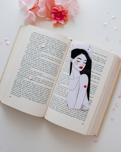 Doppelseitiges Glossy-Lesezeichen mit eleganter Frauenillustration, schwarze lange Haare, rote Lippen, roter Punkt, auf aufgeschlagenem Buch mit rosa Blüten