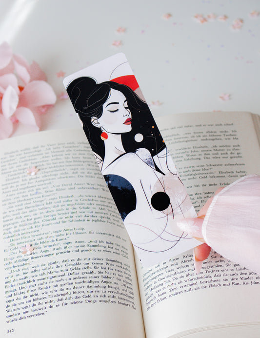 Laminiertes Lesezeichen mit eleganter Frauenillustration, schwarze Hochsteckfrisur, rotes Haarband und rote Ohrringe, schräg in aufgeschlagenem Buch mit rosa Blüten