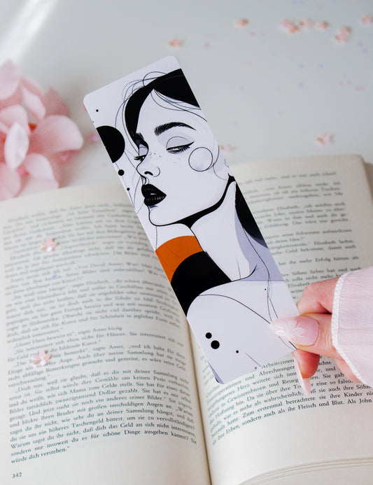 Doppelseitiges Lesezeichen Bold Line-Art-Frau mit schwarzen Lippen, orangefarbener und schwarzer Farbfläche, gehalten über aufgeschlagenem Buch