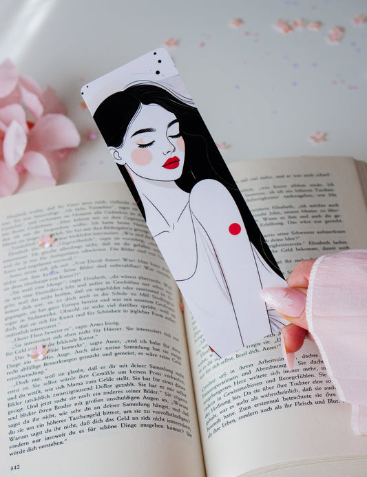 Doppelseitiges Lesezeichen mit minimalistischer Line-Art-Frau, rote Lippen, schwarze Haare, gehalten vor aufgeschlagenem Buch mit rosa Blüten