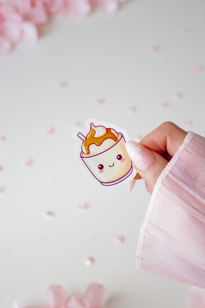 Kawaii Karamell eis Sticker, gehalten von einer Hand vor hellrosa Hintergrund