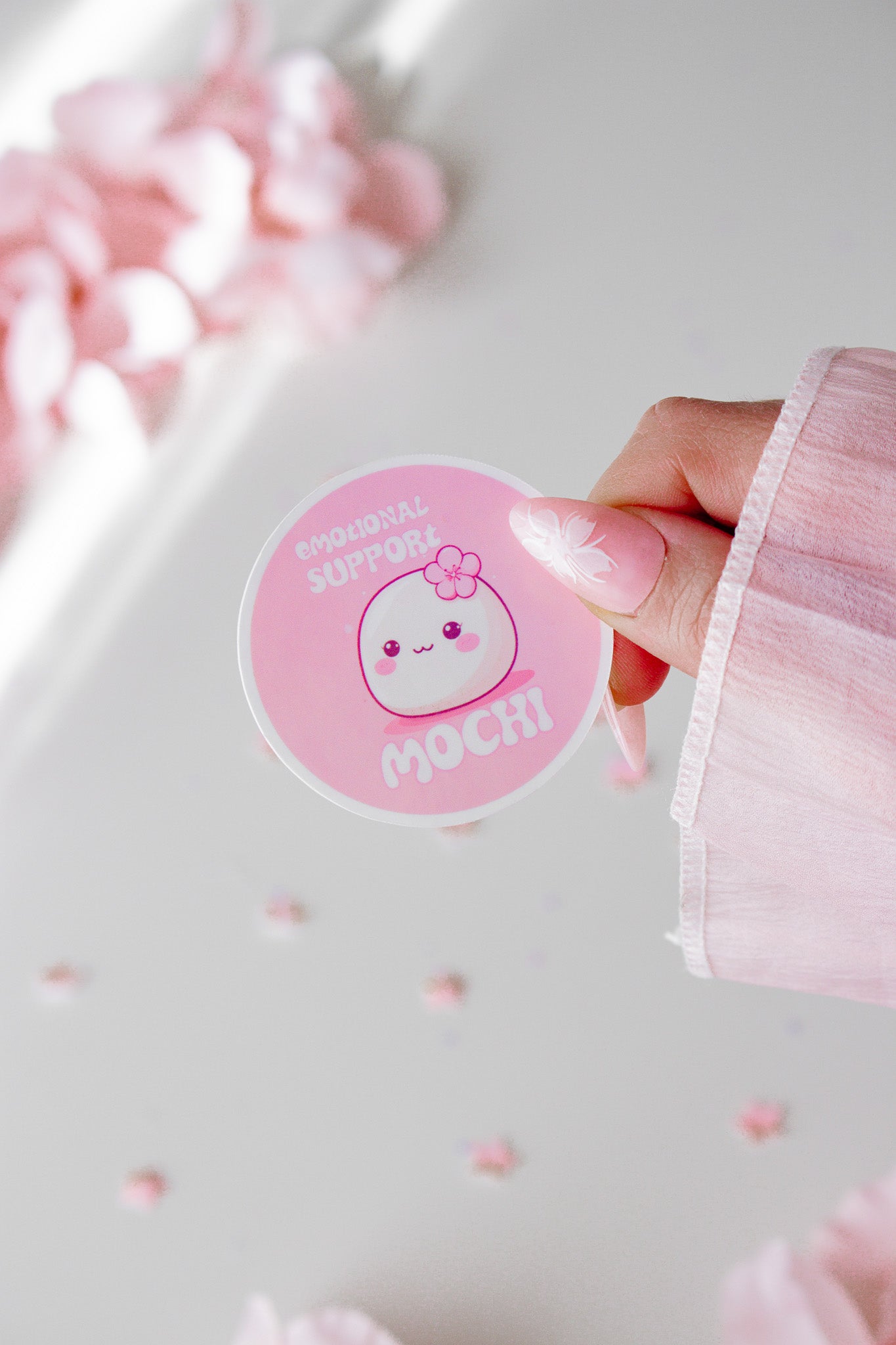 Kawaii Mochi Sticker Nahaufnahme in der Hand gehalten, rundes Design mit Kirschblüte und Schriftzug Emotional Support Mochi
