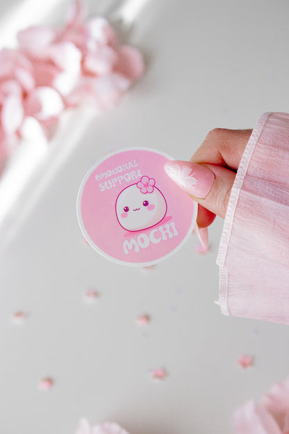 Kawaii Mochi Sticker Nahaufnahme in der Hand gehalten, rundes Design mit Kirschblüte und Schriftzug Emotional Support Mochi
