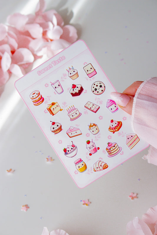 Kawaii Vinyl Sticker Bogen Sweet Taste Glossy, 20 niedliche Food-Motive mit Kawaii-Gesichtern in Pastellrosa, in der Hand gehalten vor rosa Blüten