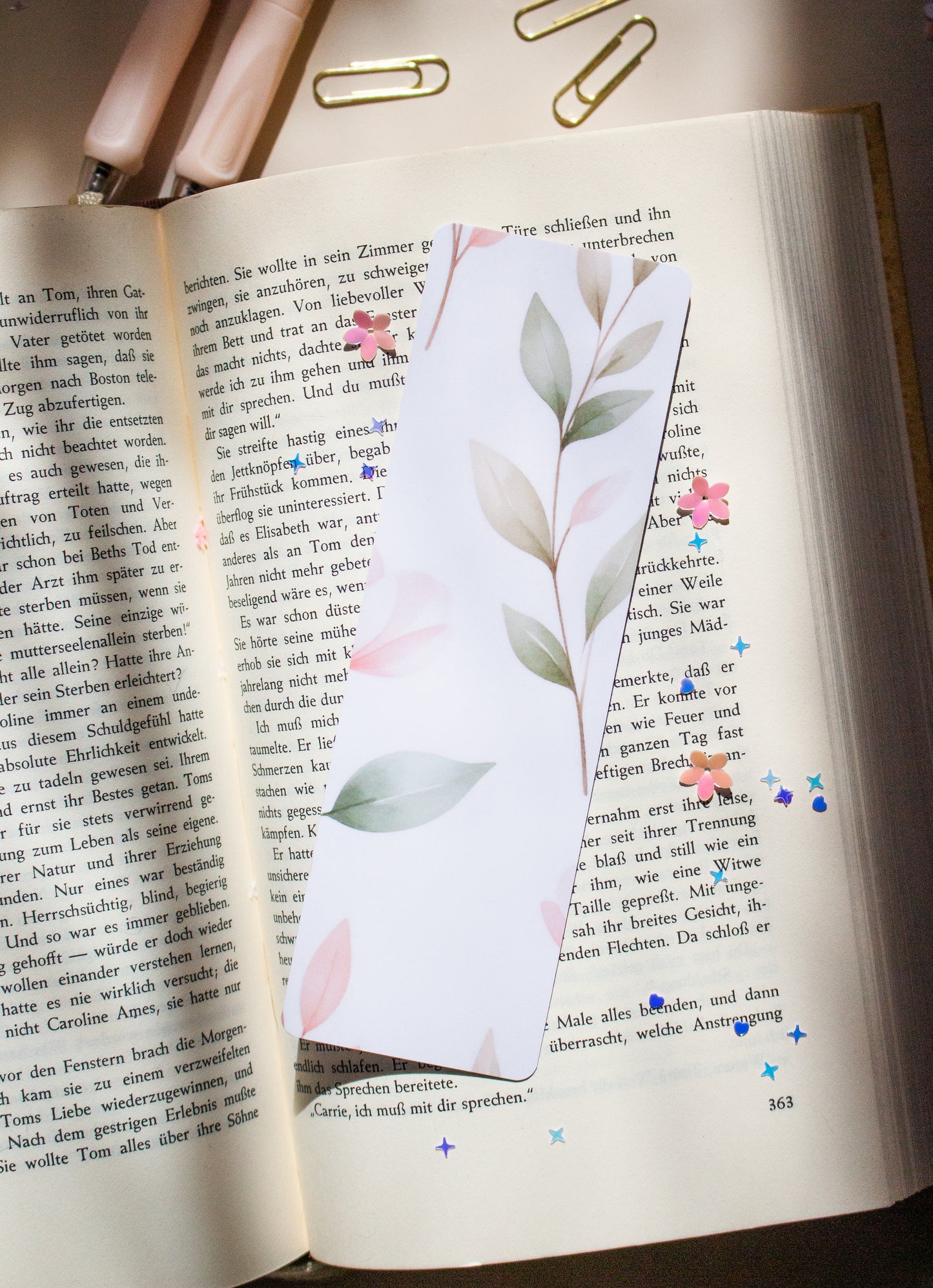 Laminiertes Aquarell Blumen Lesezeichen Glossy, bunte Wildblumen Illustration auf aufgeschlagenem Buch

