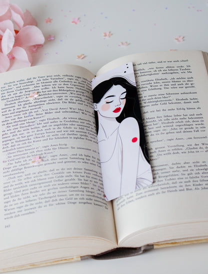 Laminiertes Lesezeichen mit eleganter Line-Art-Illustration einer Frau mit roten Lippen und schwarzen Haaren, auf aufgeschlagenem Buch