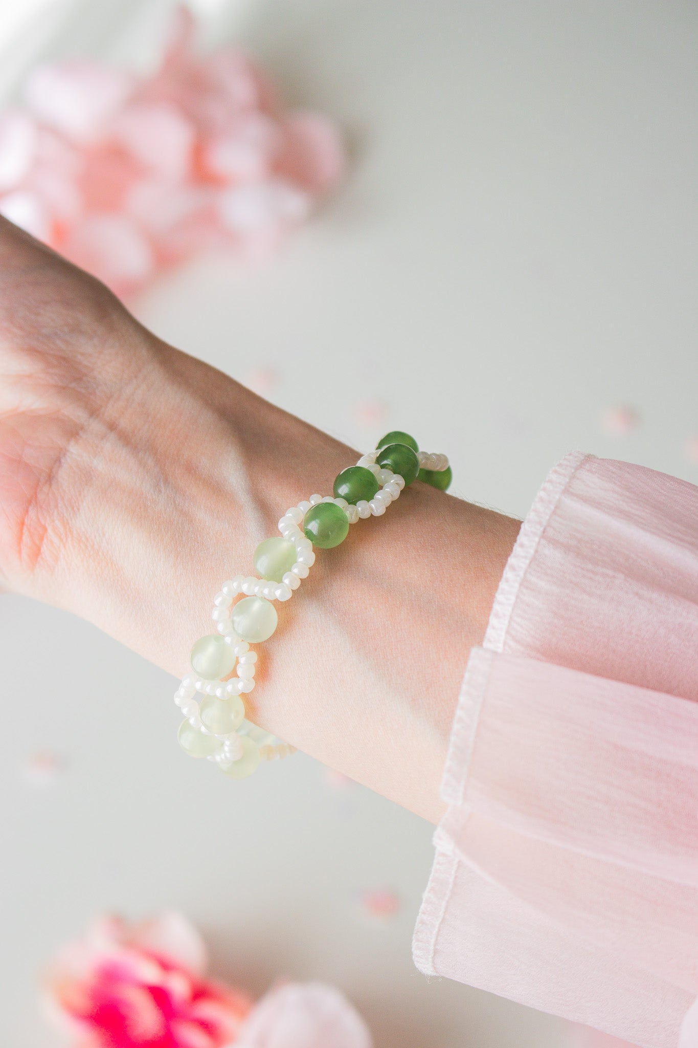 Perlenarmband Grün mit weißen Perlen am Handgelenk – Nahaufnahme von oben