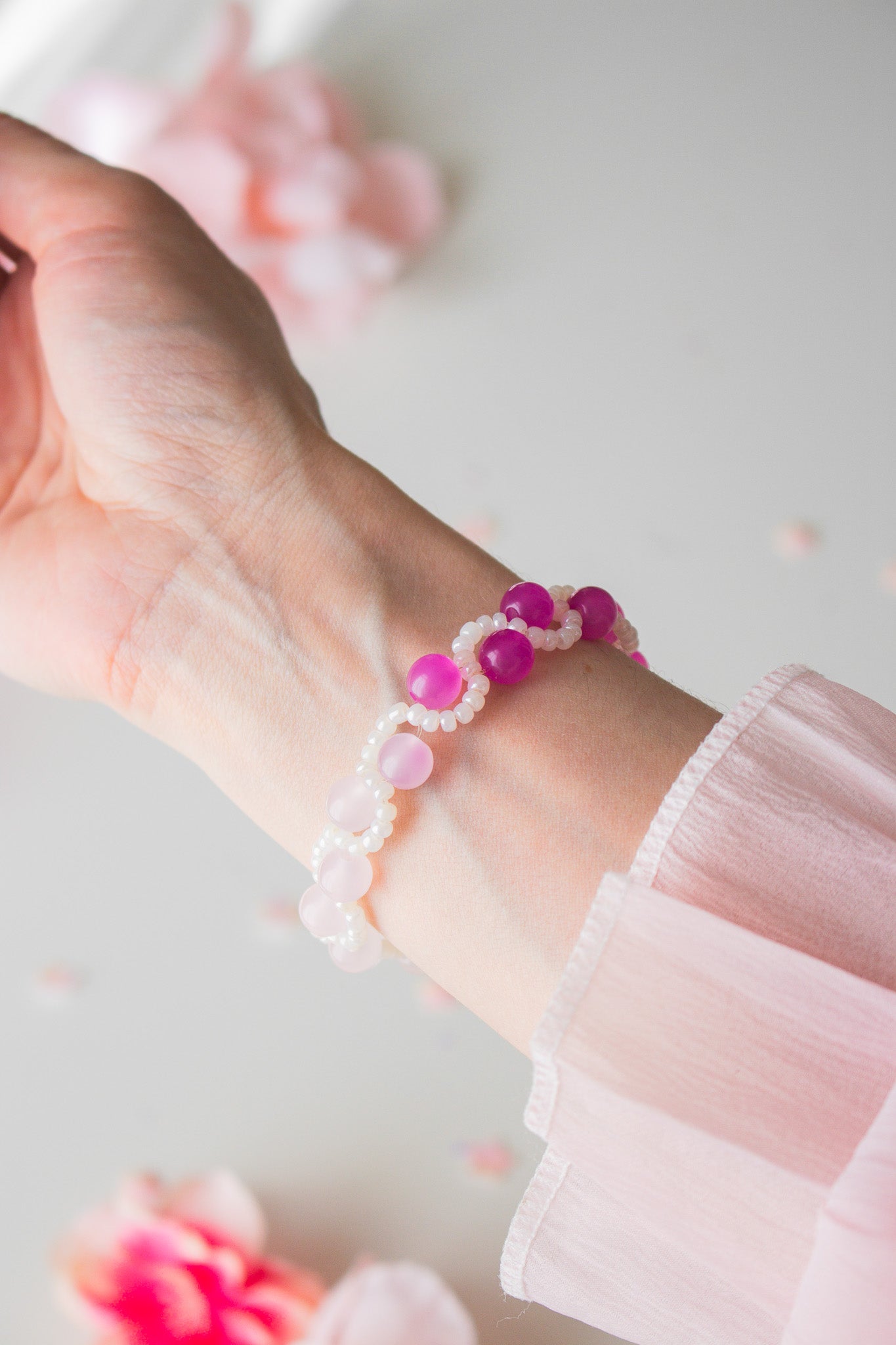 UV-Farbwechsel Armband am Handgelenk – große pinke und kleine weiße Acrylperlen im Sonnenlicht aktiviert