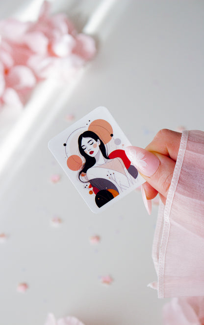 Vinyl Sticker mit eleganter Frauenillustration, schwarze lange Haare, rote Lippen, abstrakte Kreise in Altrosa, Rot, Orange und Schwarz, in der Hand gehalten vor rosa Blüten